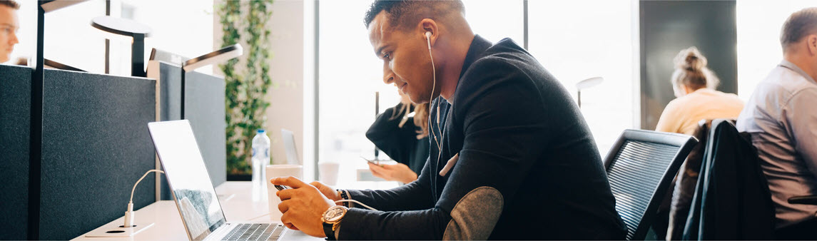 Southern Cross - Office worker listening to music at his desk Office worker listening to music at his desk